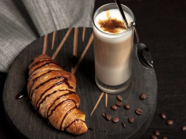 Latte and croissant on a board